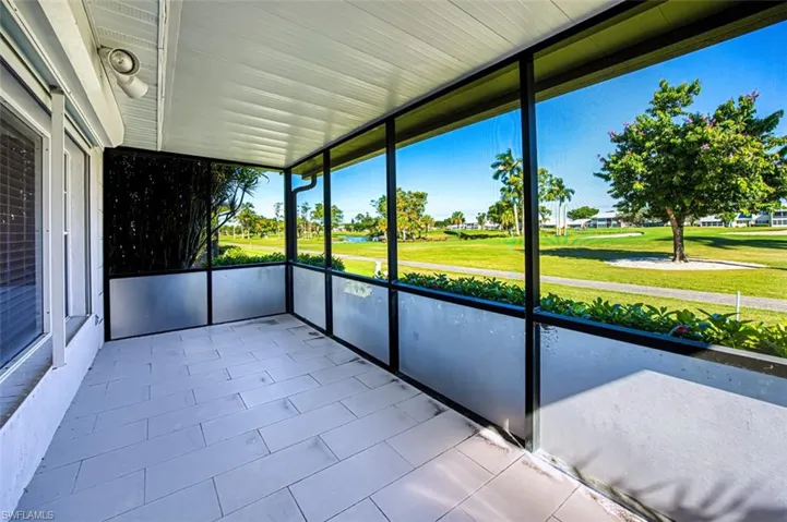 Unfurnished sunroom with view of golf course and a water view