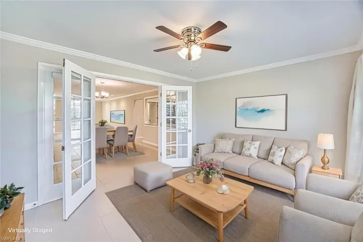 *VIRTUALLY STAGED*Spare room with crown molding, light tile patterned flooring, a chandelier, and a ceiling fan