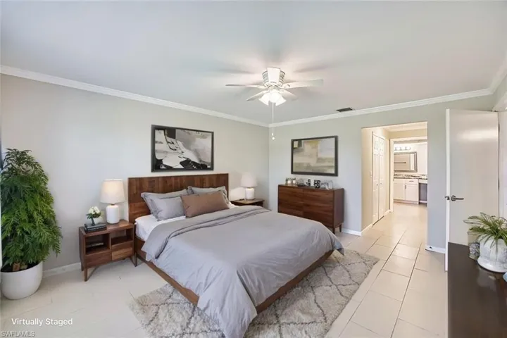*VIRTUALLY STAGED*Bedroom with ornamental molding, light tile patterned floors, ceiling fan, and connected bathroom