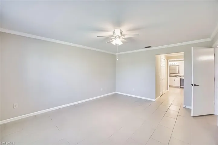 Unfurnished room featuring crown molding, ceiling fan, and light tile patterned floors