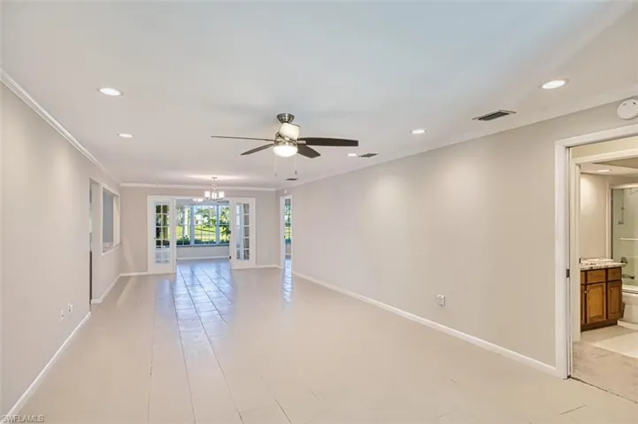 Unfurnished room featuring recessed lighting, ornamental molding, ceiling fan, french doors, and a chandelier