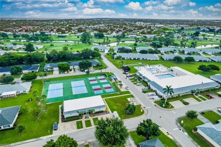 Aerial perspective of suburban area featuring a nearby body of water and a golf club
