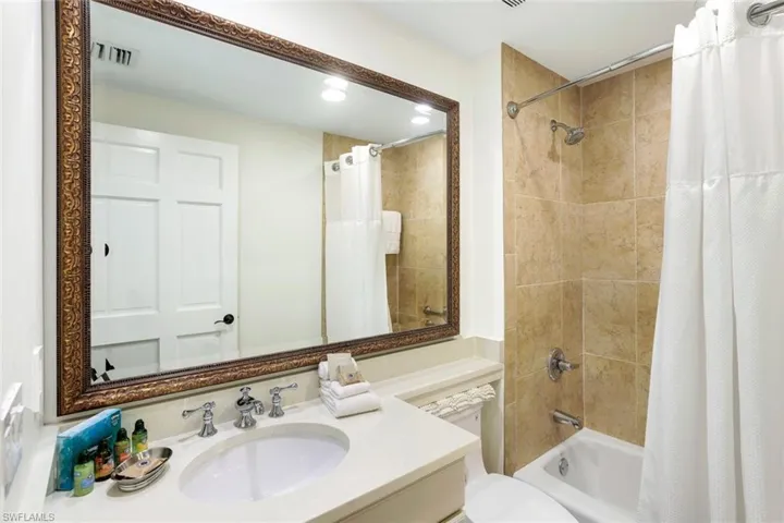 Full bathroom featuring toilet, shower / bath combo with shower curtain, and vanity