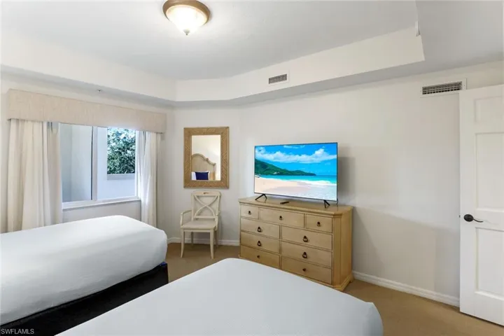 Carpeted bedroom featuring a raised ceiling