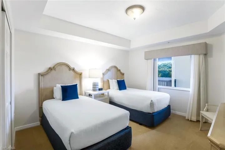 Carpeted bedroom featuring a raised ceiling