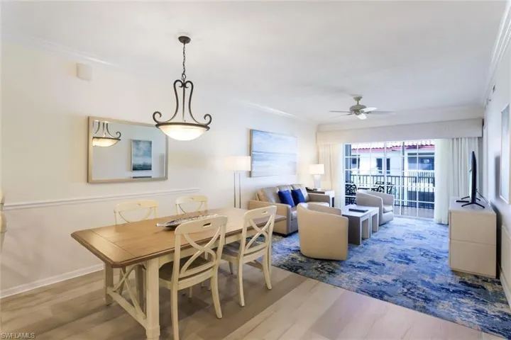 Dining space with ornamental molding, ceiling fan, and light wood-type flooring