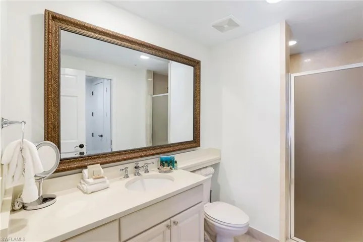 Bathroom featuring vanity, a shower with shower door, and toilet