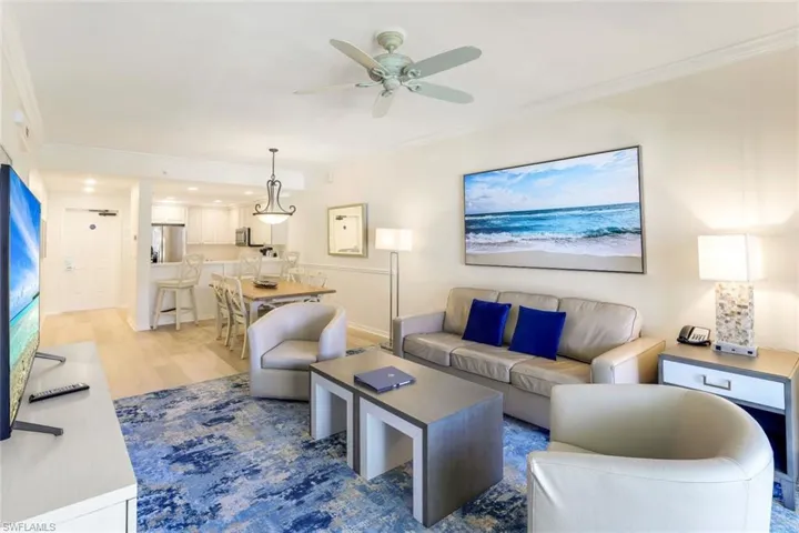 Living room featuring ceiling fan, crown molding, and wood-type flooring