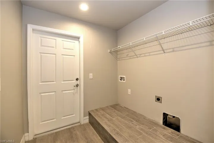 Laundry area with hookup for a washing machine, light wood-type flooring, and electric dryer hookup