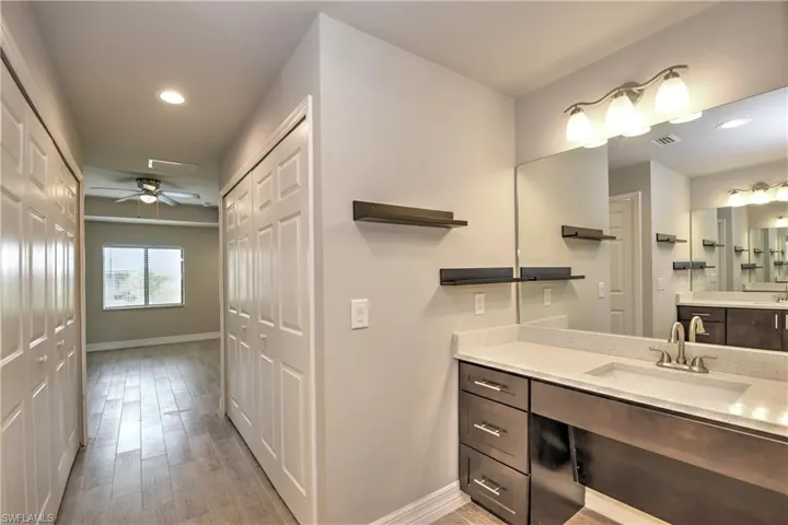 Bathroom with ceiling fan, hardwood / wood-style floors, and vanity