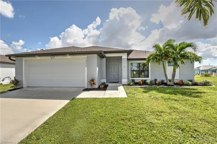 Ranch-style house featuring a front yard and a garage