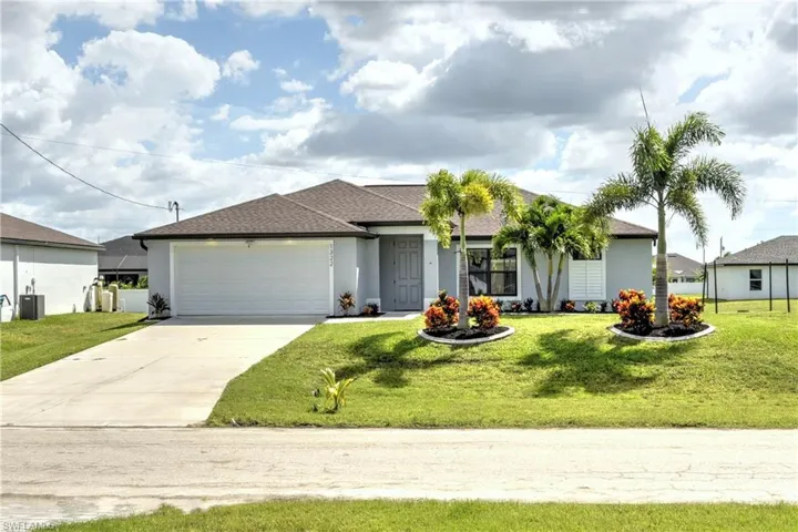 Single story home featuring a garage and a front lawn