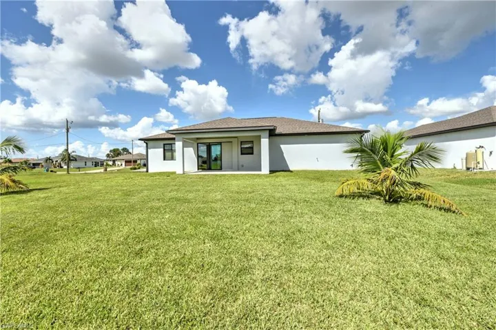 Rear view of house with a yard and a patio area