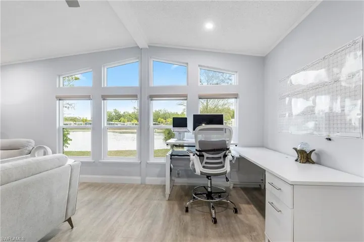 Home office with beamed ceiling and light wood-type flooring