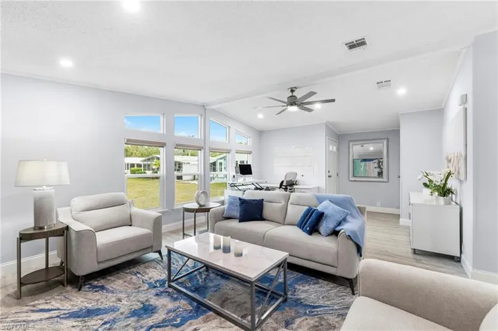 Living room featuring a ceiling fan, wood finished floors, recessed lighting, and beamed ceiling