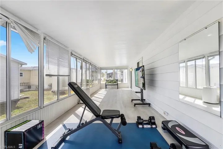 Exercise area featuring wood walls and light wood finished floors
