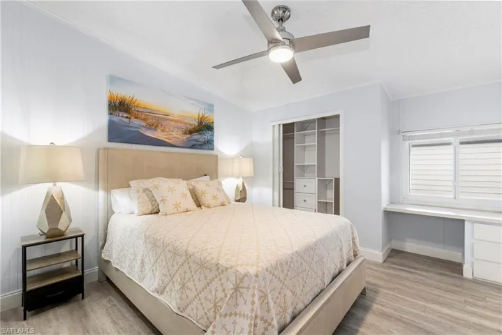 Bedroom featuring ornamental molding, a ceiling fan, light wood-type flooring, and a textured ceiling