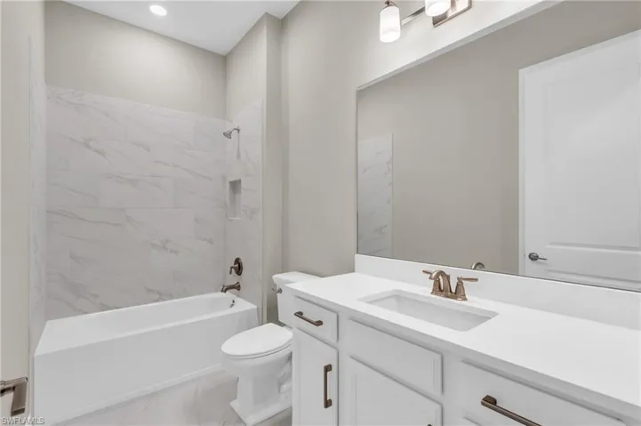Full bathroom with vanity, toilet, and tiled shower / bath combo