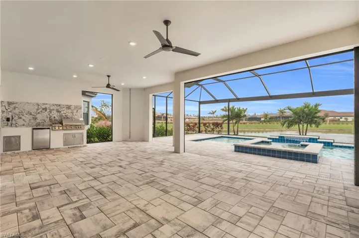 View of pool with area for grilling and ceiling fan