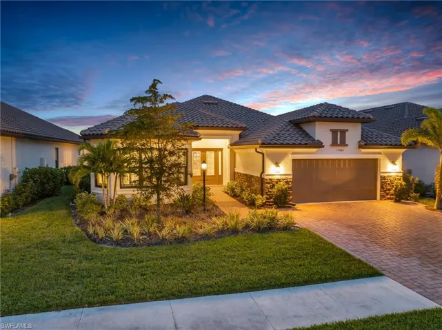 View of front of property featuring a garage and a lawn