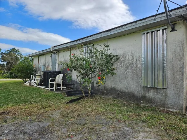 View of property exterior with central AC and a lawn