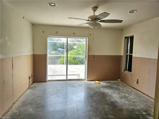 Spare room featuring concrete floors ceiling fan, walk in closet & sliders out to the lanai