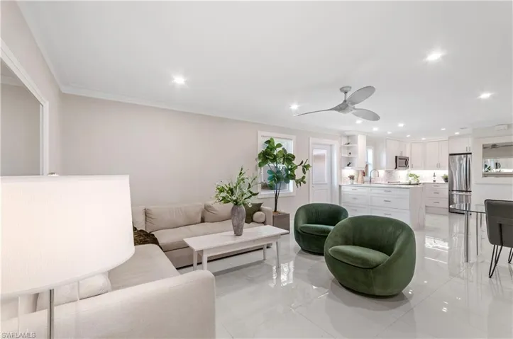 Living room featuring crown molding, recessed lighting, a ceiling fan, and light marble finish flooring