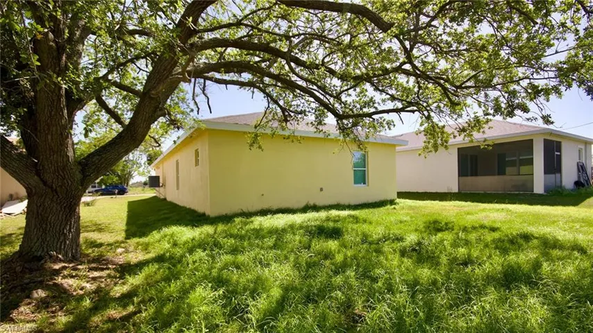 View of property exterior featuring a sunroom, stucco siding, and a yard