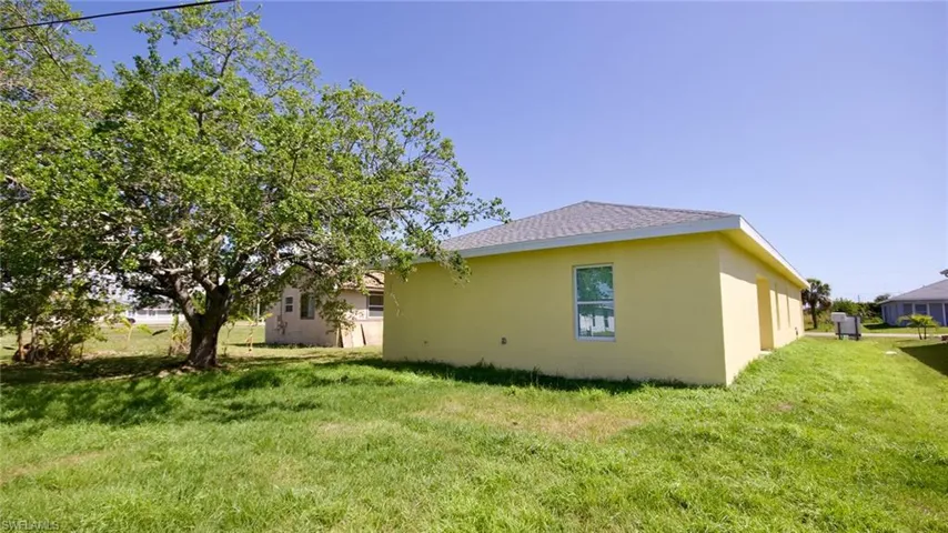 View of home's exterior with stucco siding and a yard