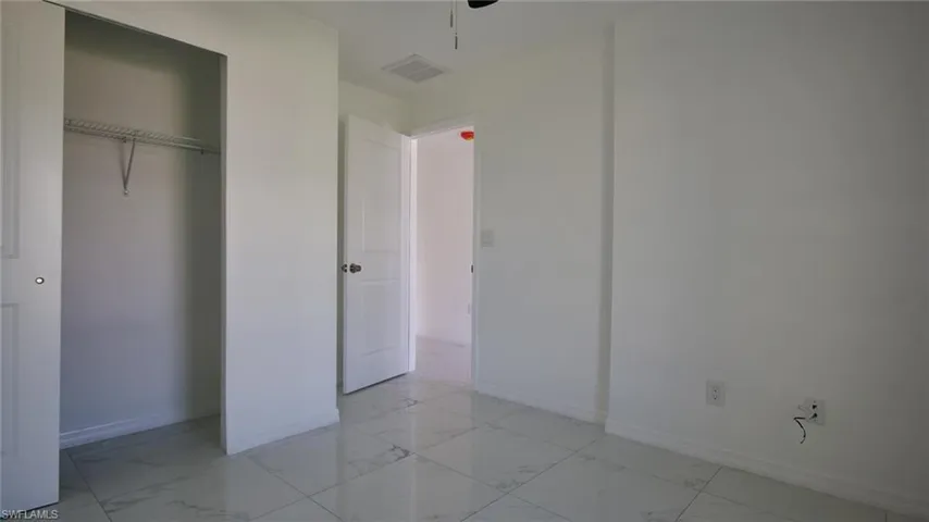 Unfurnished bedroom with baseboards and marble finish floor