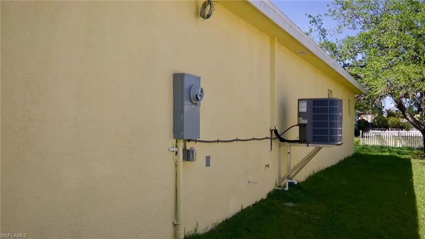 View of home's exterior featuring a lawn, cooling unit, fence, and stucco siding