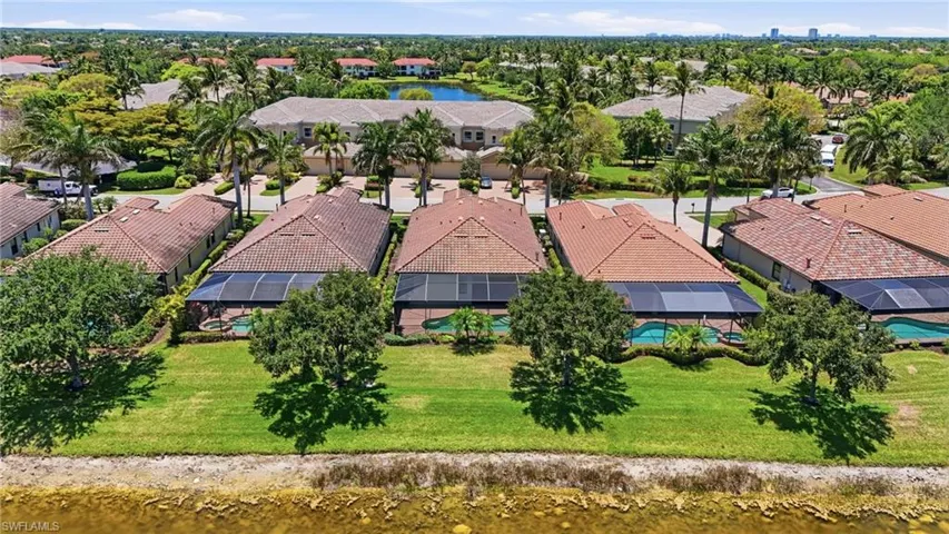Expansive residential area featuring properties with red tile roofs, enclosed screened patios, and individual swimming pools