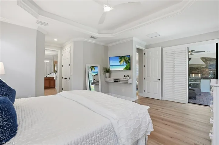 Spacious interior featuring wood-finish flooring, a tiered tray ceiling, and crown molding