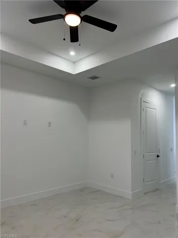 Empty room featuring light marble finish floors, recessed lighting, and a ceiling fan