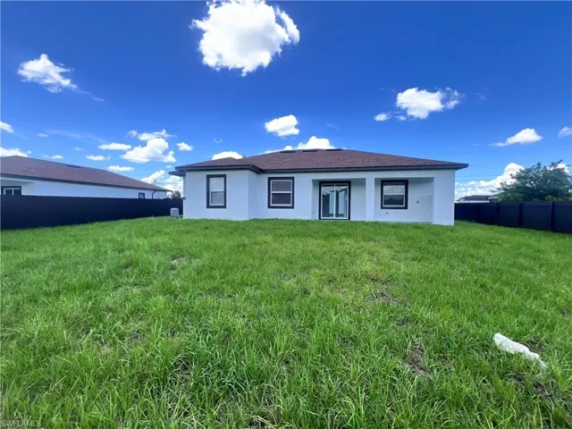 Rear view of house featuring stucco siding and a fenced backyard