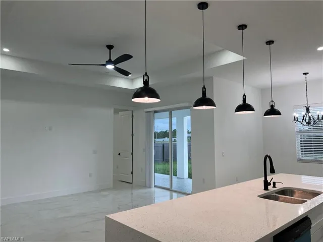 Kitchen featuring dishwasher, a ceiling fan, recessed lighting, pendant lighting, and light marble finish floors