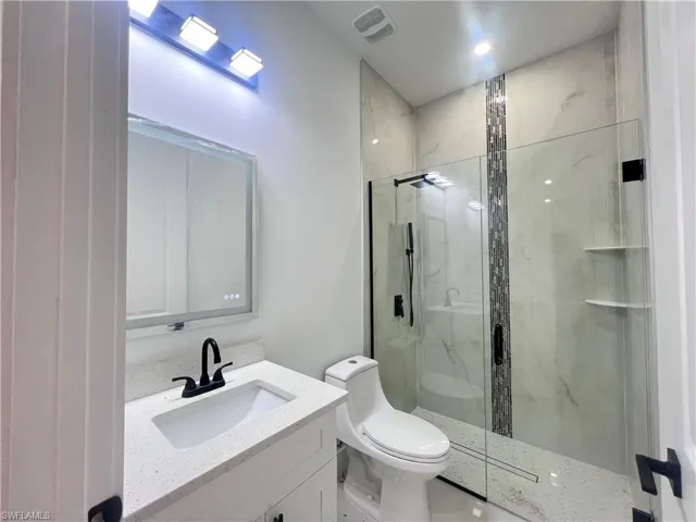 Full bath with vanity and a marble finish shower