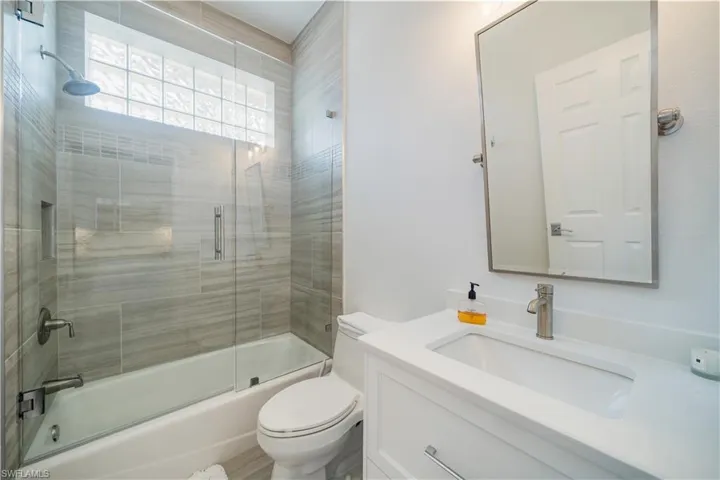 Full bathroom with combined bath / shower with glass door