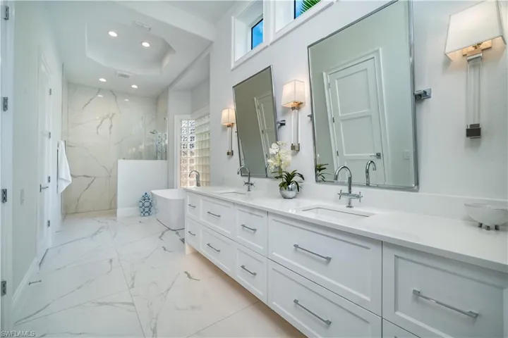 Bathroom with vanity, a raised ceiling, and shower with separate bathtub