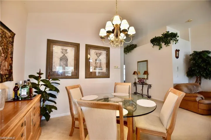 Dining space featuring an inviting chandelier and light colored carpet