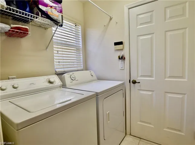 Laundry area featuring separate washer and dryer and light tile patterned floors