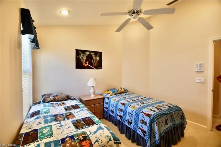 Carpeted bedroom featuring ceiling fan