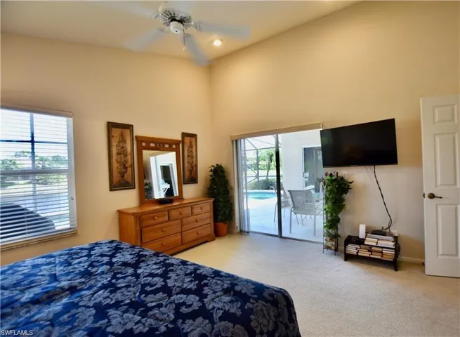 Bedroom featuring carpet floors, access to exterior, ceiling fan, and high vaulted ceiling