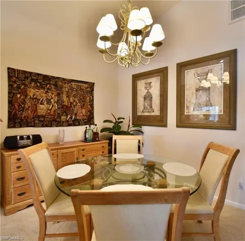 Dining room featuring carpet and an inviting chandelier