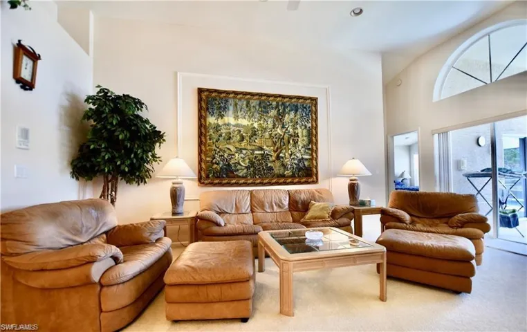 Carpeted living room with high vaulted ceiling