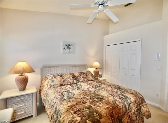 Bedroom with lofted ceiling, light colored carpet, a closet, and ceiling fan