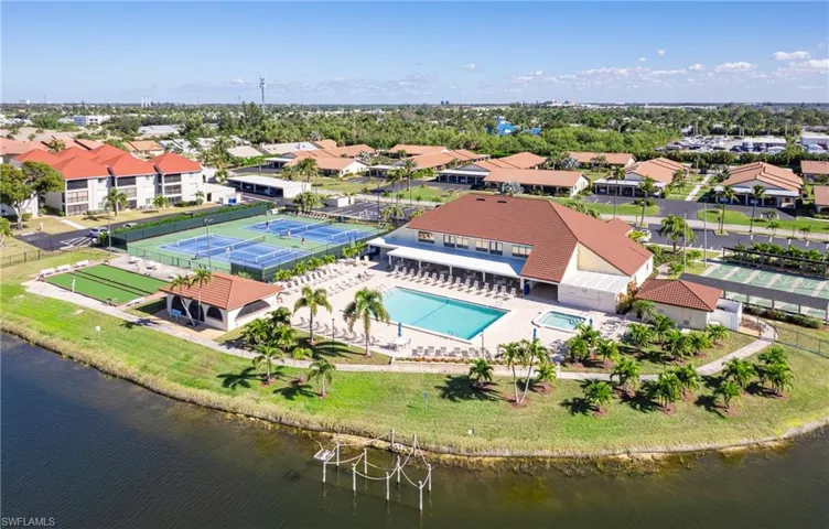 Aerial view of residential area featuring a pool area and a nearby body of water