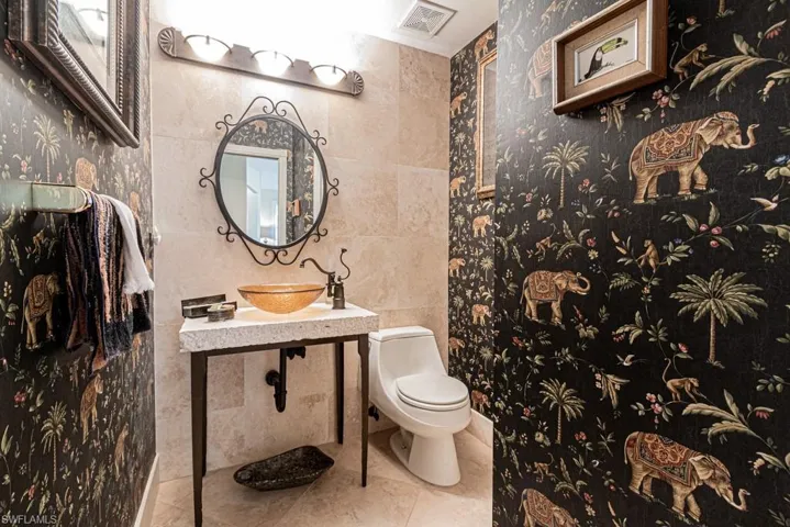 Bathroom featuring tile patterned floors, sink, tile walls, and toilet