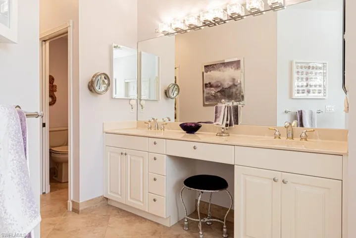 Bathroom with dual vanity, toilet, and tile patterned flooring