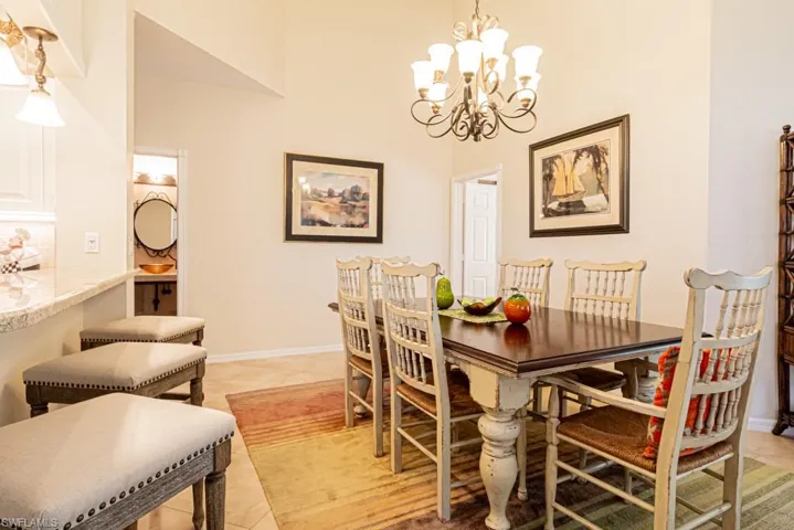 Tiled dining room with a high ceiling and a chandelier